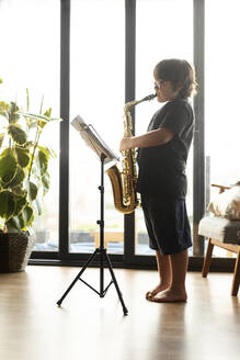 Junge übt zu Hause das Saxophonspielen - VABF03091