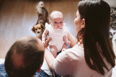 Niedliches Baby mit Eltern und Hund im Wohnzimmer zu Hause - EBBF00190