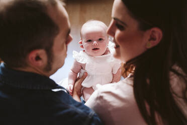 Niedliches Baby schaut die Eltern im Wohnzimmer an - EBBF00191
