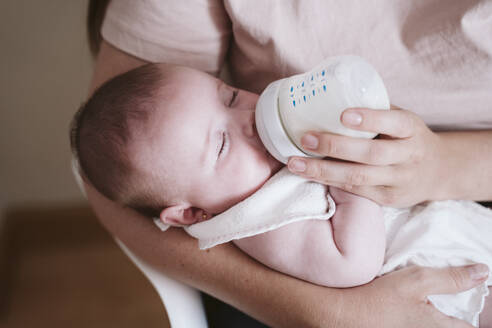 Mutter füttert ihr Baby zu Hause mit der Flasche - EBBF00192