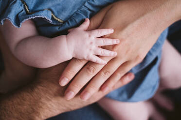 Baby girl's hand on father and mother at home - EBBF00208