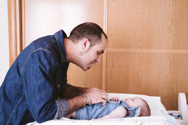 Father playing with baby girl at home - EBBF00209