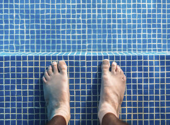 Füße eines Mannes, der knöcheltief im Schwimmbad steht - EHF00362