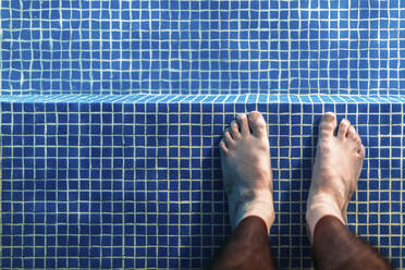 Füße eines Mannes, der knöcheltief im Schwimmbad steht - EHF00363