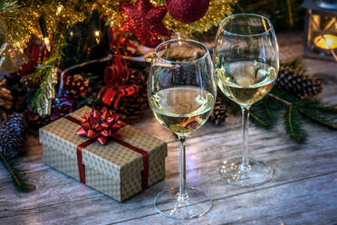 Nahaufnahme von Weingläsern mit Weihnachtsdekoration auf dem Tisch - EYF07224