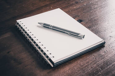 High Angle View Of Pen And Book On Table - EYF07304