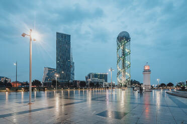 Georgien, Adscharien, Batumi, Beleuchteter Stadtplatz in der Abenddämmerung mit Batumi-Leuchtturm und Alphabetischem Turm im Hintergrund - WVF01798