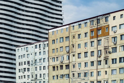 Georgia, Adjara, Batumi, Old residential buildings with wavy apartment block in background - WVF01808