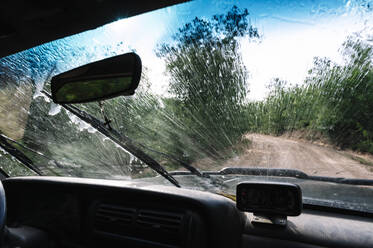 Spritzwasser auf der Windschutzscheibe eines Fahrzeugs während einer Autofahrt - JCMF00906