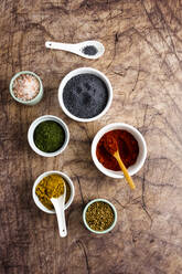 Bowls of poppy seeds, pink salt, curry powder, dried thyme, coriander seeds, red paprika - GIOF08448