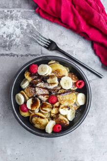 Schüssel mit hausgemachten Mini-Pfannkuchen mit Bananen, Himbeeren, Schokoladensauce und Puderzucker - SARF04603