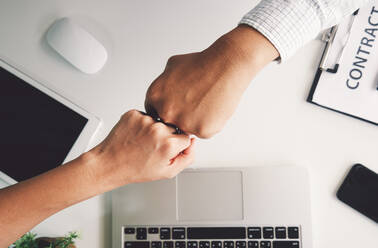 Cropped Hände von Geschäftsleuten geben Fist Bump über Schreibtisch im Büro - EYF07445