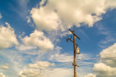Low Angle View Of Electricity Pylon gegen bewölkten blauen Himmel - EYF07494