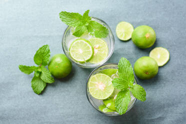 High Angle View of Drinks mit Limetten und Minze Blätter auf dem Tisch - EYF07498