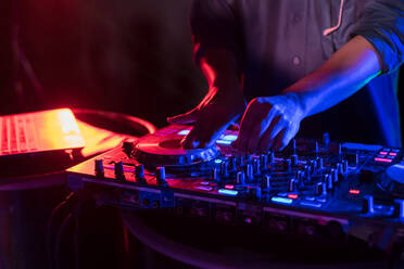 Close-Up Of Man Playing Music On Audio Equipment In Nightclub - EYF07504