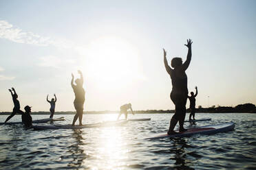 Silhouette Menschen üben auf Paddleboard in Meer gegen Himmel - EYF07541