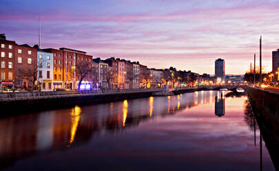 Illuminated Buildings By River Against Sky At Sunset - EYF07557