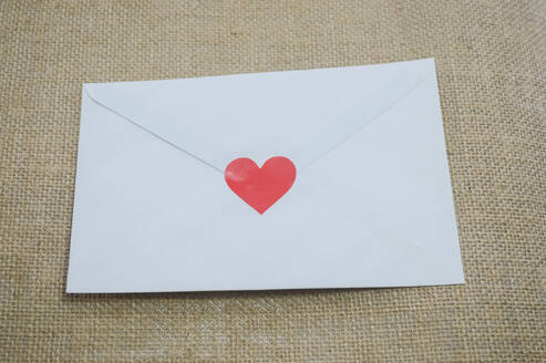 High Angle View Of Heart Shape Stuck On White Envelope On Sack - EYF07571