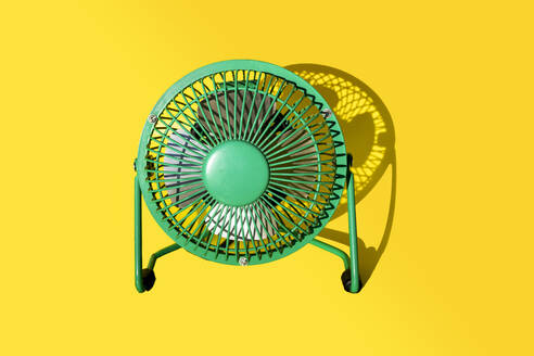 Green electric fan against yellow background - GEMF03881