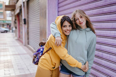 Portrait of two smiling and hugging female friends in the city - TCEF00790