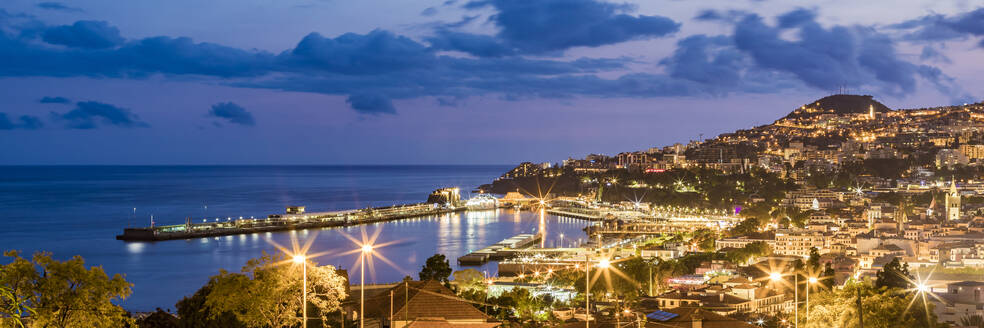 Portugal, Funchal, Panorama der beleuchteten Küstenstadt in der Abenddämmerung - WDF06095