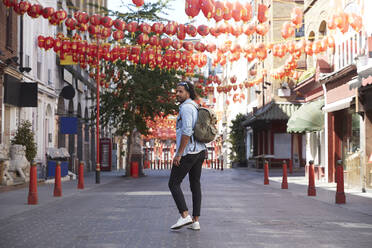 Young man walking on street, Chinatown, London, UK - PMF01127