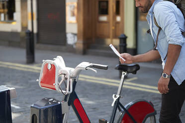 Crop view of man using rental bike in the city, London, UK - PMF01135