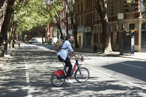 Junger Mann mit Mietfahrrad in der Stadt, London, UK - PMF01137