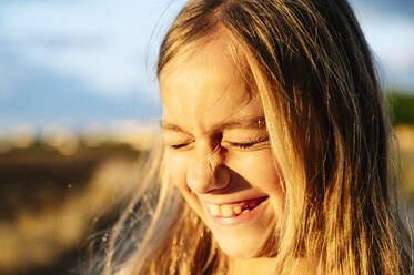 Close-up of cheerful blond girl with eyes closed - JCMF00928