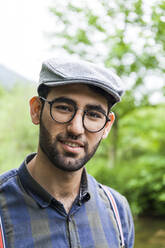 Portrait of young man wearing glasses and cap - TCF06287