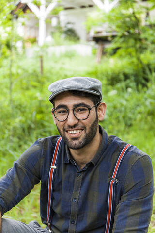 Porträt eines lächelnden jungen Mannes mit Brille und Mütze, lizenzfreies Stockfoto