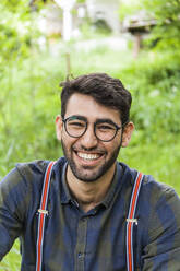 Portrait of laughing young man wearing glasses - TCF06289