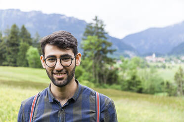 Portrait of smiling young man wearing glasses, Reichenwies, Oberammergau, Gerrmany - TCF06290