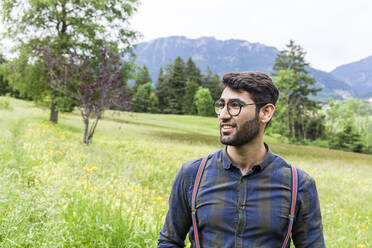 Portrait of smiling young man on a meadow, Reichenwies, Oberammergau, Gerrmany - TCF06292