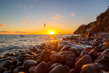 Nahaufnahme von Kieselsteinen am Strand gegen den Himmel bei Sonnenuntergang - EYF07609