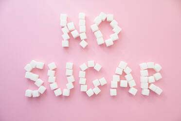 Directly Above Shot Of No Sugar Text Made With Food Over Pink Background - EYF07641