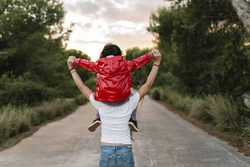 Rear view of mother with daughter on her shoulders - EGAF00281