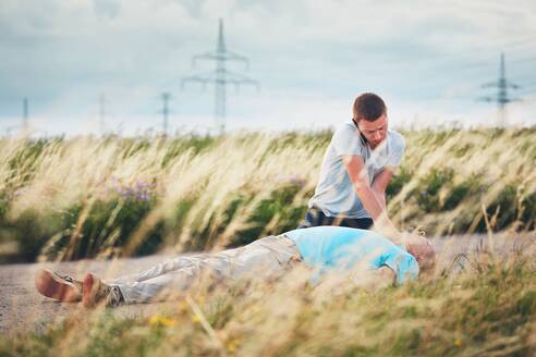 Volle Länge des Mannes auf Gras gegen den Himmel liegend - EYF07722