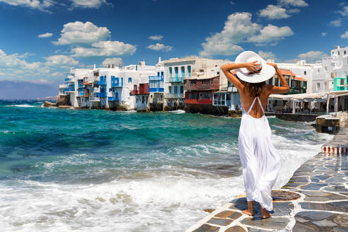 Rückansicht der jungen Frau, die einen Hut trägt, der am Strand gegen den Himmel steht, an einem sonnigen Tag - EYF07729