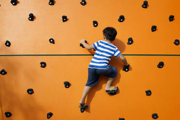 Rear View Of Boy Climbing Wall - EYF07735