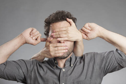 Cropped Image of Hand Covering Man Augen gegen weißen Hintergrund - EYF07752