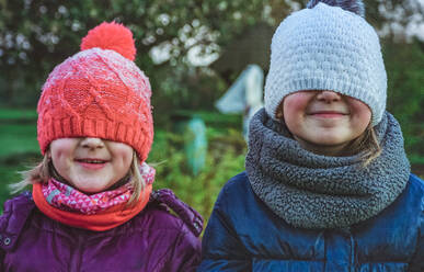 Nahaufnahme von spielerischen Schwestern tragen warme Kleidung im Park im Winter - EYF07758