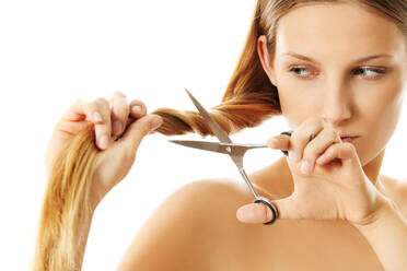 Close-Up Of Woman Cutting Her Hair Against White Background - EYF07802