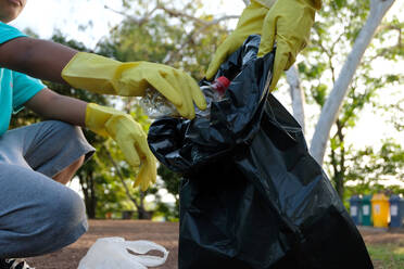 Cropped Image Of People Picking Garbage From Road - EYF07807