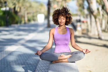 Full Length Of Young Woman Performing Yoga Outdoors - EYF07854