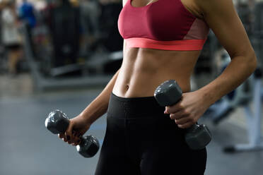 Midsection Of Woman Exercising In Gym - EYF07875