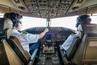 Rear View Of Male Pilots Flying Airplane - EYF07934