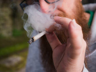 Mittelteil eines Mannes, der einen Marihuana-Joint raucht - EYF07944