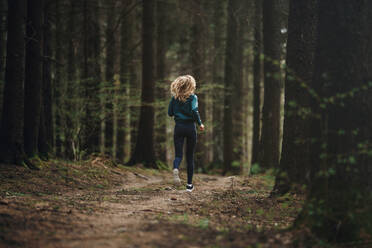 Rückansicht in voller Länge der Frau läuft im Wald - EYF07945