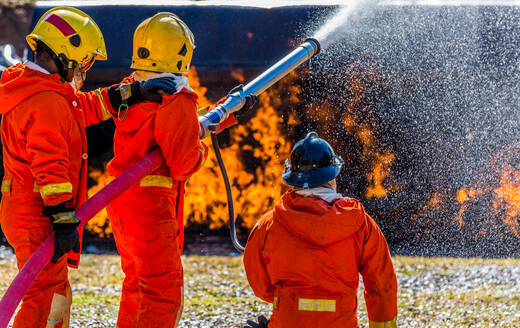 Feuerwehrleute sprühen Wasser auf Feuer - EYF07952